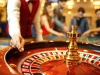 The croupier holds a roulette ball in a casino in his hand.
