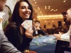 Girl with cards in her hands smiles at winning poker in a casino.